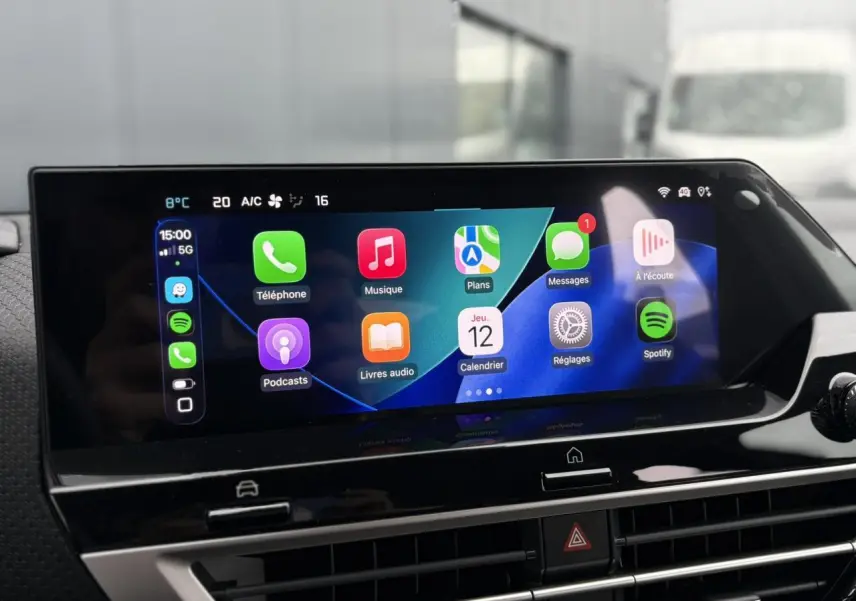 Écran tactile central de la Citroën C4 Hybrid 2025 affichant Apple CarPlay avec icônes colorées, vue intérieure frontale.