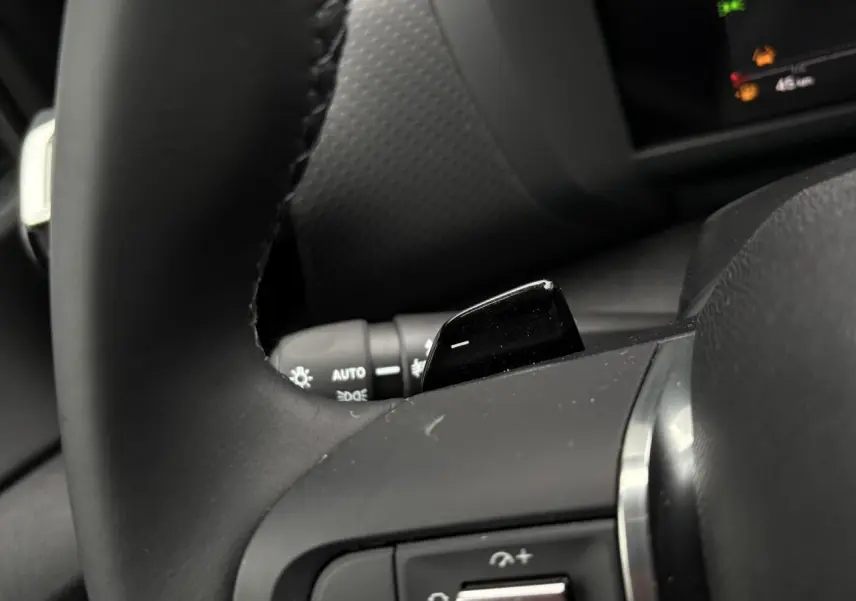 Gros plan sur la palette de changement de rapports côté droit du volant cuir de la Citroën C4 Hybrid 145 rouge Elixir.