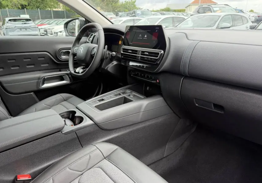 Vue intérieure côté conducteur du Citroën C5 Aircross 2025 noir avec tableau de bord moderne et écran tactile central.