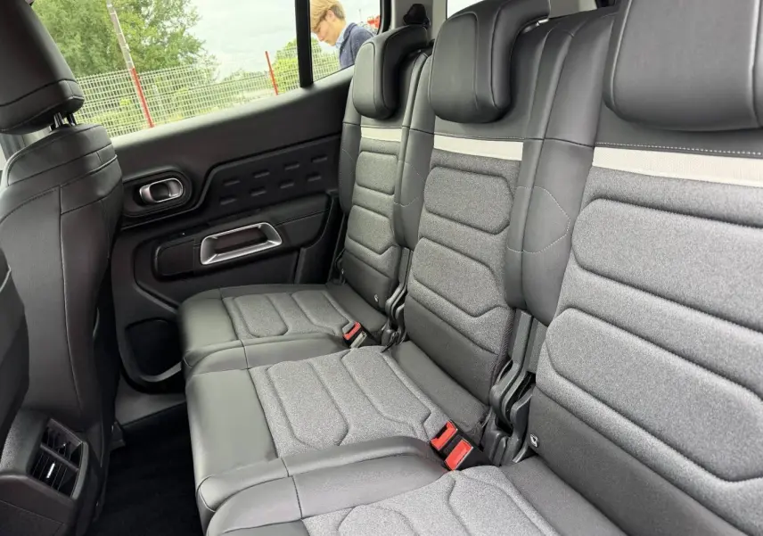 Vue latérale des trois sièges individuels arrière en tissu gris et cuir noir du Citroën C5 Aircross 2025.