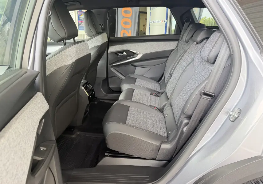 Vue intérieure côté droit des sièges arrière en tissu gris et cuir noir du Peugeot 1007 Hybrid 145 gris artense 2026.