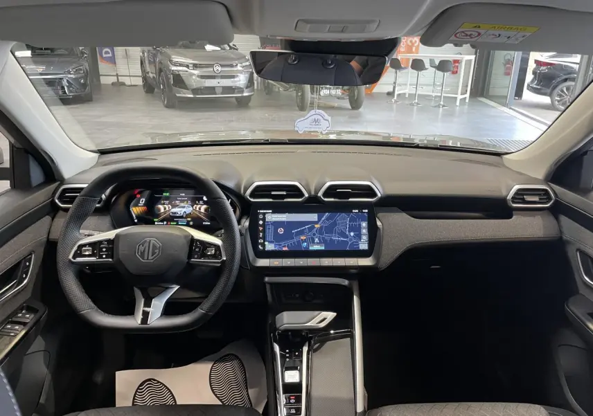 Vue intérieure frontale du MG ZS 1.5 Hybrid+ 2026 avec tableau de bord noir et écran tactile central affichant la navigation.