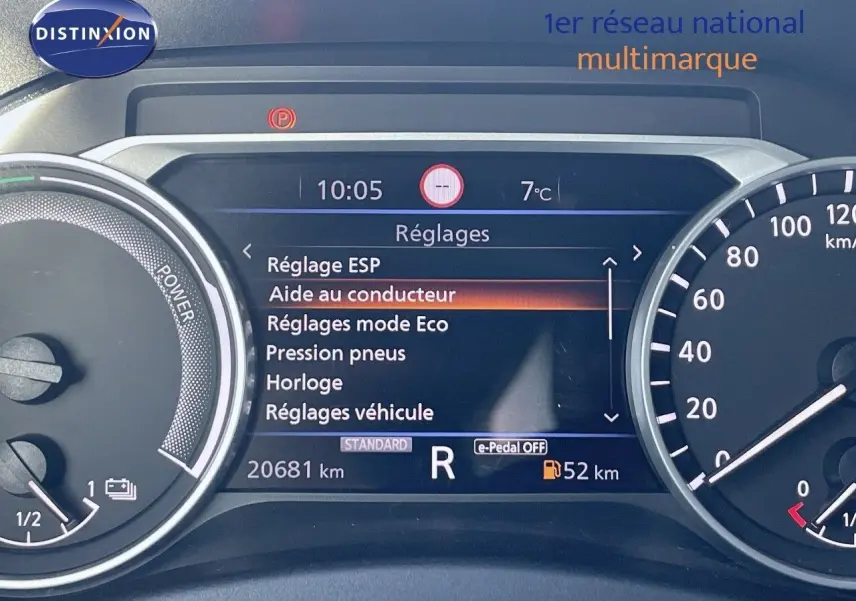 Tableau de bord numérique du Nissan Juke gris squale métal 2024 affichant les réglages et la vitesse en marche arrière.