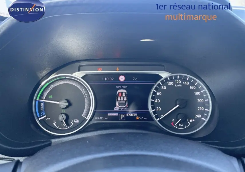 Tableau de bord du Nissan Juke gris squale métal 2024, affichage numérique et compteurs analogiques vus de face.