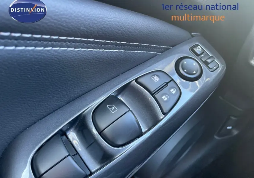 Gros plan sur les commandes de lève-vitres et rétroviseurs côté conducteur du Nissan Juke gris squale métal 2024.