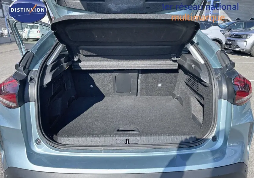 Coffre ouvert vu de l'arrière d'une Citroën C4 bleu Iceland Metal, montrant l'espace de chargement vide.