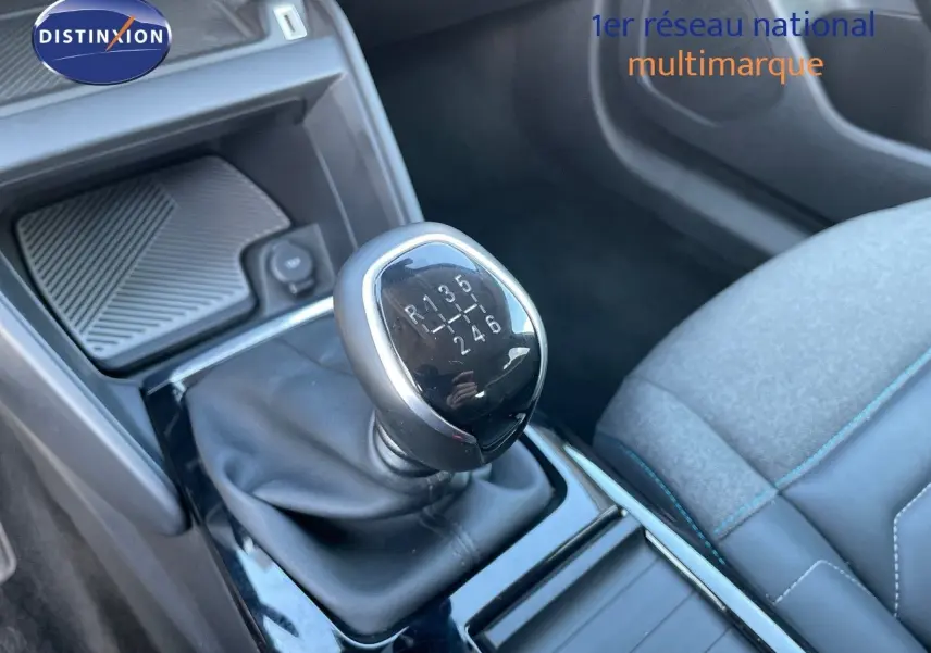 Gros plan sur le levier de vitesse manuel de la Citroën C4 2021, avec siège tissu gris et coutures bleues en arrière-plan.