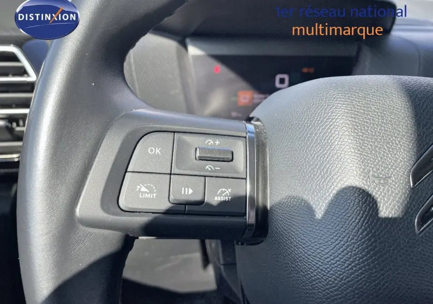 Gros plan sur les commandes au volant côté gauche d’une Citroën C4 1.2 PureTech 130ch 2021, intérieur noir.