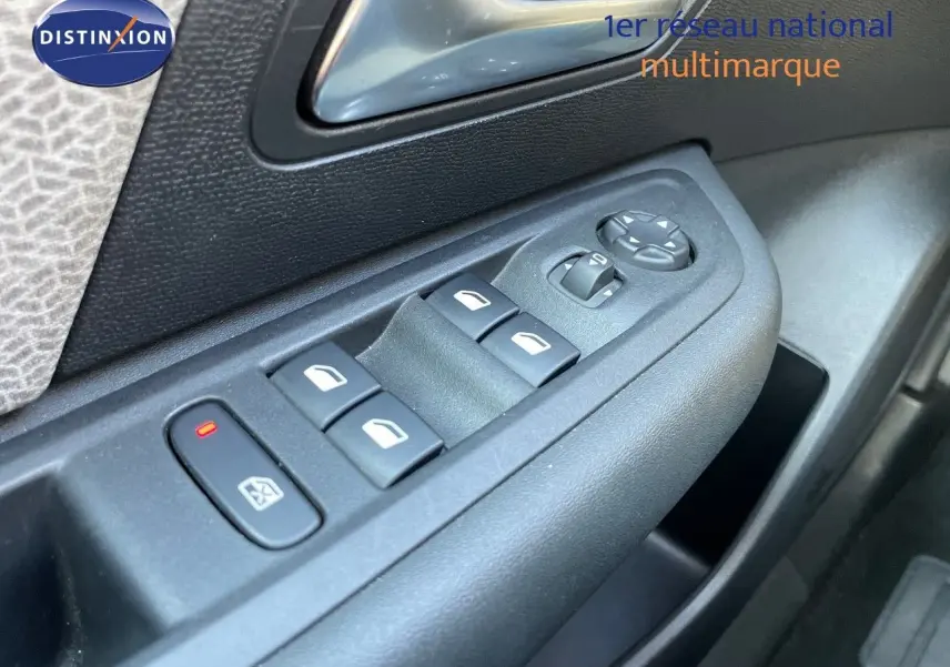 Gros plan sur les commandes des vitres électriques et rétroviseurs côté conducteur d'une Citroën C4 bleu Iceland Metal.