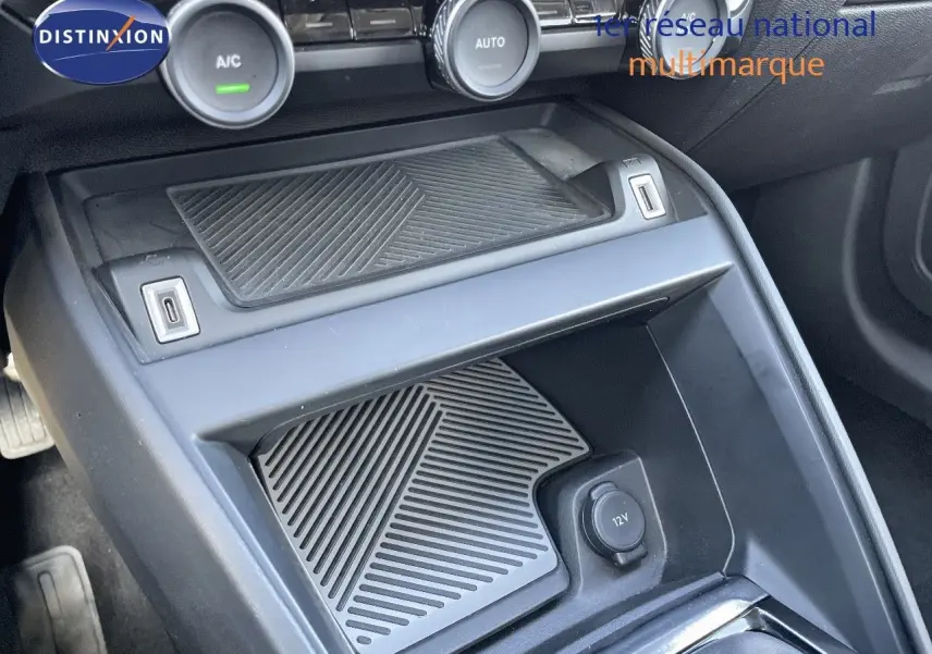 Gros plan sur la console centrale avant de la Citroën C4 bleu Iceland Metal, montrant la prise 12V et les commandes de climatisation.