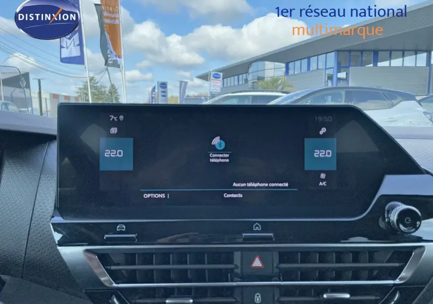 Vue intérieure centrée sur l'écran tactile du tableau de bord d'une Citroën C4 bleu Iceland Metal, avec commandes climatisation visibles.