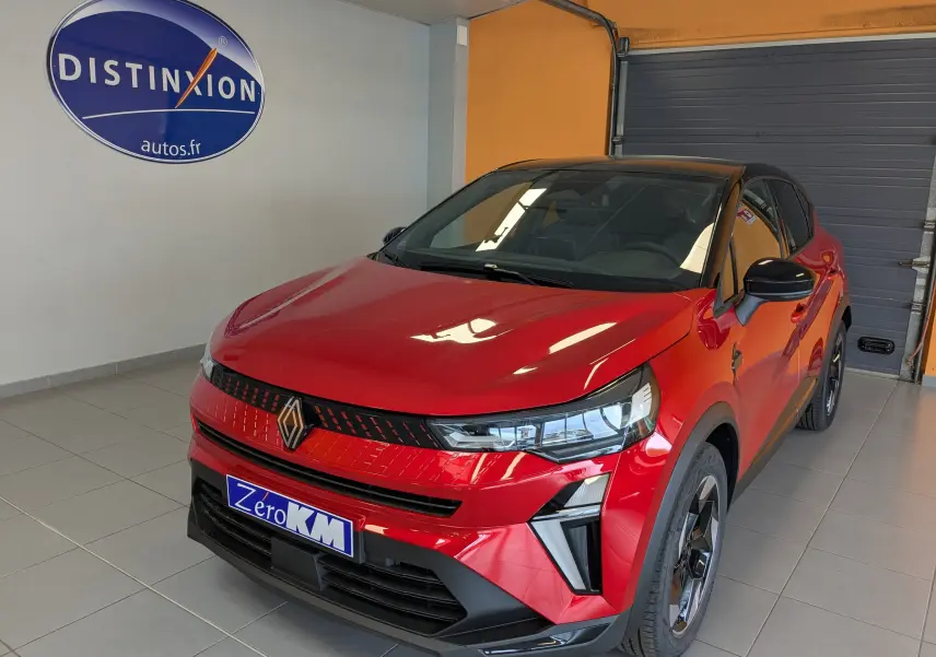 Vue 3/4 avant d'un Renault Captur E-Tech rouge flamme avec toit noir et jantes alliage 18 pouces noir brillant en showroom.