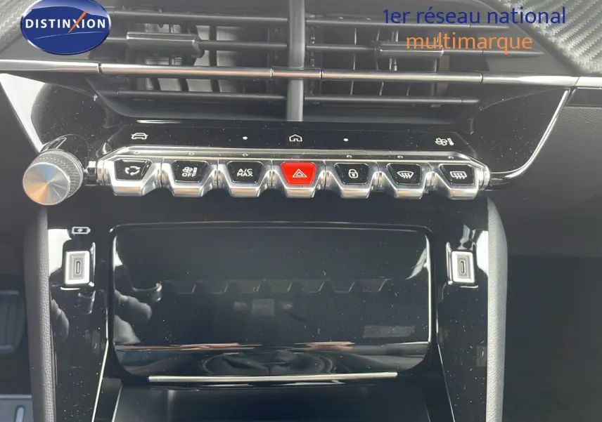 Vue rapprochée de la console centrale noire brillante du Peugeot 2008 2024 avec boutons de commande et écran tactile éteint.