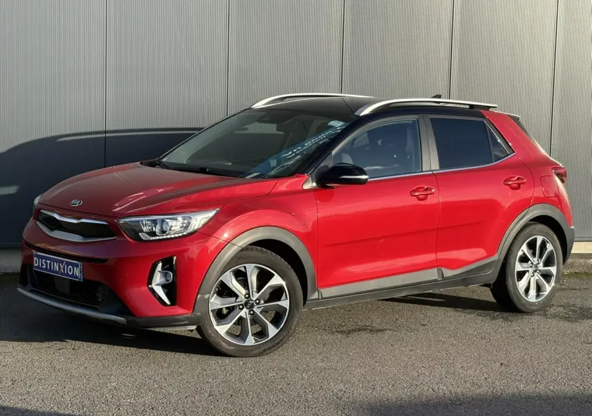 KIA Stonic rouge métallisé vue 3/4 avant droit avec jantes alliage et toit ouvrant panoramique.