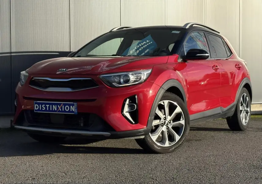 KIA Stonic rouge métallisé vue 3/4 avant droit avec toit noir et jantes alliage 17 pouces.