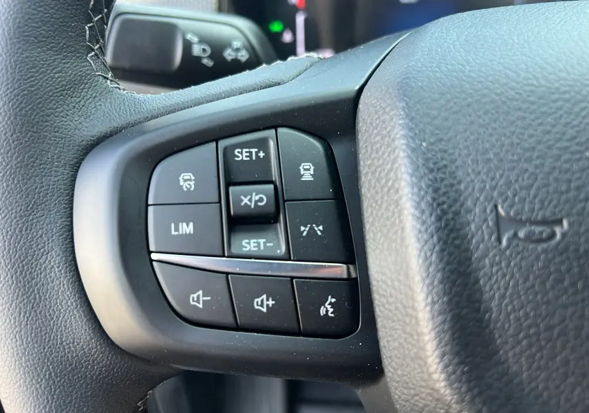 Gros plan sur les commandes multifonctions du volant en cuir du Ford Ranger gris iconic 2025, version Tremor Cover.
