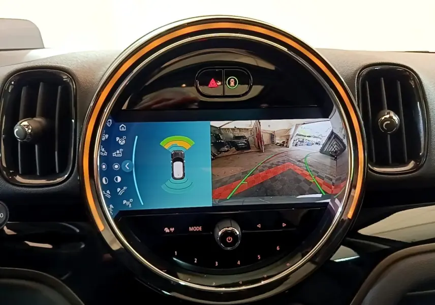 Écran central circulaire du tableau de bord MINI Countryman Cooper SE, affichant la caméra de recul et capteurs de stationnement.