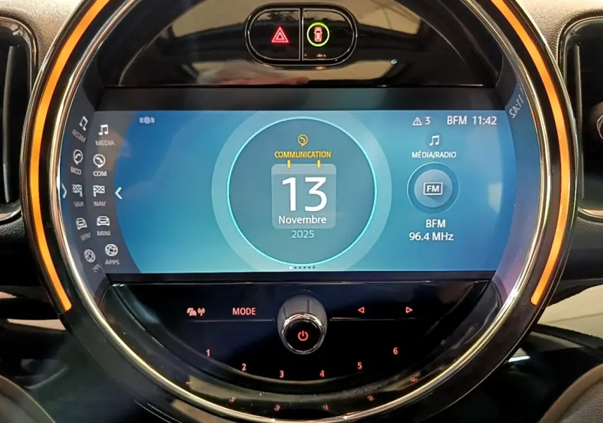 Écran tactile central circulaire du tableau de bord de la MINI Countryman Cooper SE vert, affichant la date et radio FM.