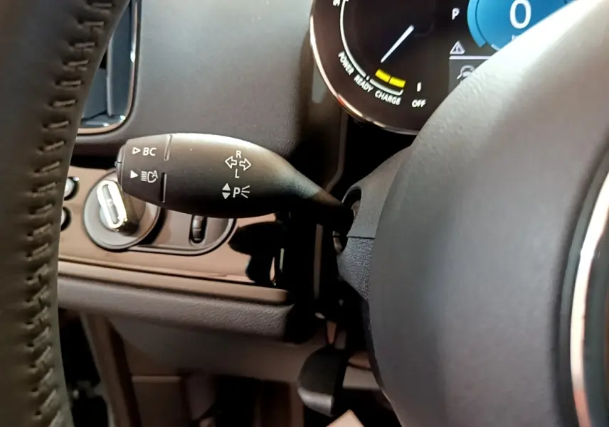 Gros plan sur la manette de clignotant noire côté gauche du volant cuir d’un MINI Countryman vert hybride 2023.