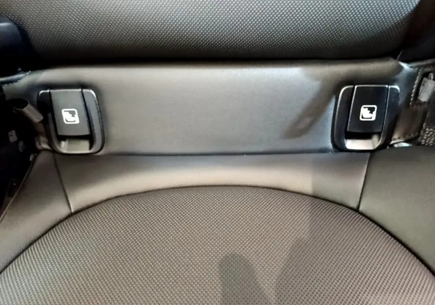 Détail des attaches Isofix noires sur siège arrière en tissu gris foncé du MINI Countryman vert hybride 2023