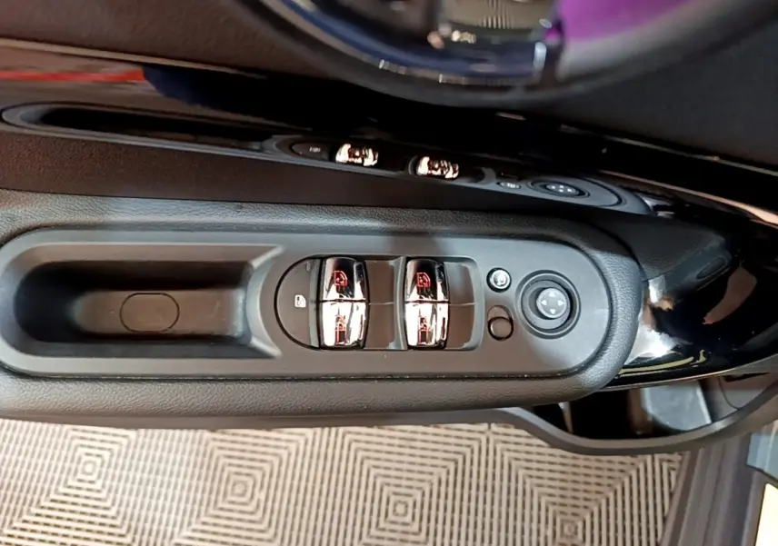 Détail des commandes de lève-vitres et rétroviseurs sur la porte côté conducteur d'une MINI Countryman 2023.
