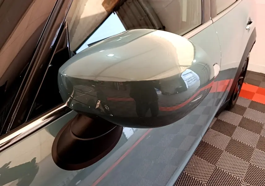 Rétroviseur côté gauche vert brillant du MINI Countryman 2023, vue rapprochée sur la portière et la poignée.