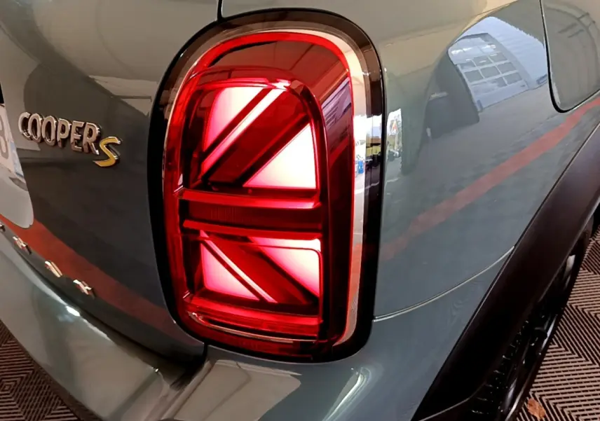 Feu arrière droit rouge en forme de drapeau britannique sur MINI Countryman Cooper S vert vue arrière côté droit.