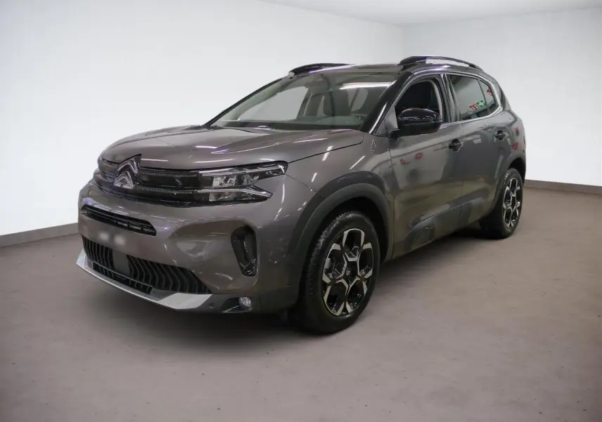 Citroën C5 Aircross Hybrid gris Platinium en 3/4 avant droit, avec jantes alliage bi-ton et barres de toit noires.