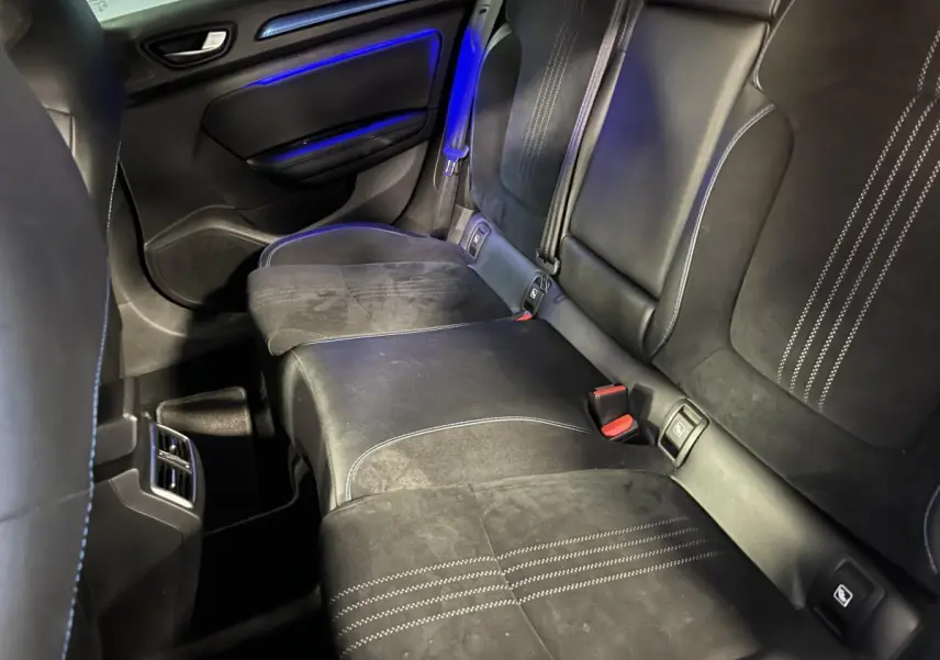 Vue intérieure arrière côté droit de la Renault Mégane GT 2016 avec sellerie alcantara noire et surpiqûres bleues, éclairage d'ambiance bleu.