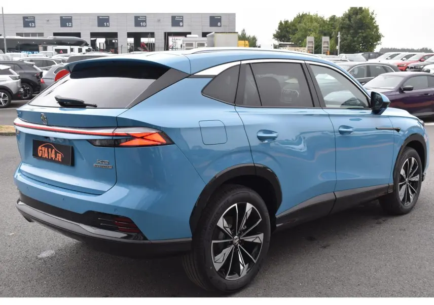 Vue 3/4 arrière droite du MG Motor EHS 1.5 Hybrid+ bleu 2026 avec feux arrière fins et jantes noires bicolores.