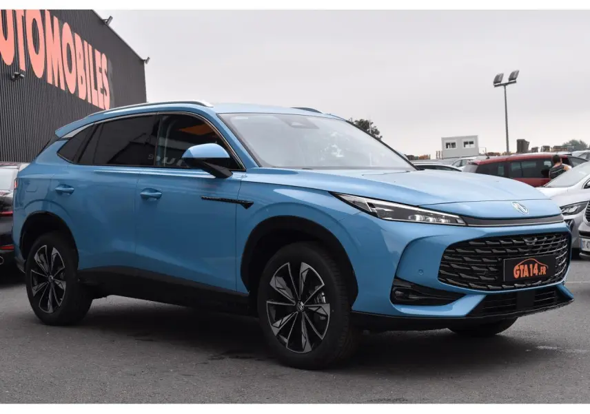 MG Motor EHS 1.5 Hybrid+ bleu 2026 en 3/4 avant droit, avec calandre large et jantes noires distinctives.