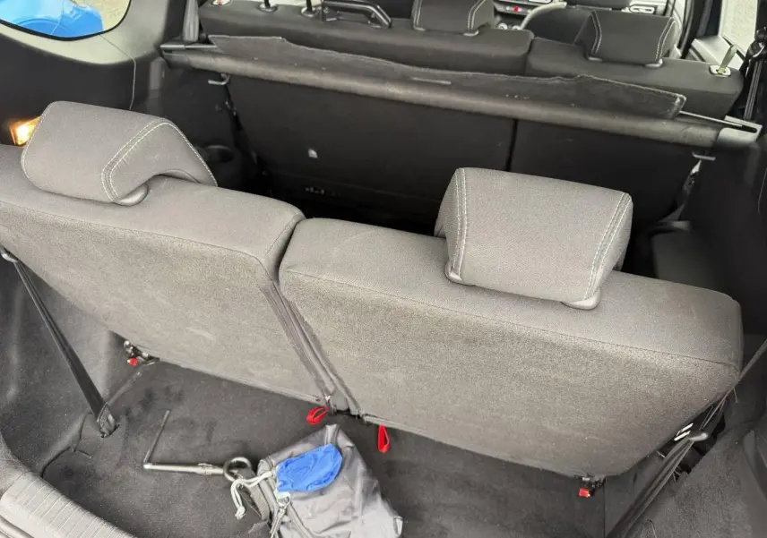Vue arrière intérieure du coffre du Dacia Jogger 2025, montrant la banquette arrière en tissu gris et les appuie-têtes.