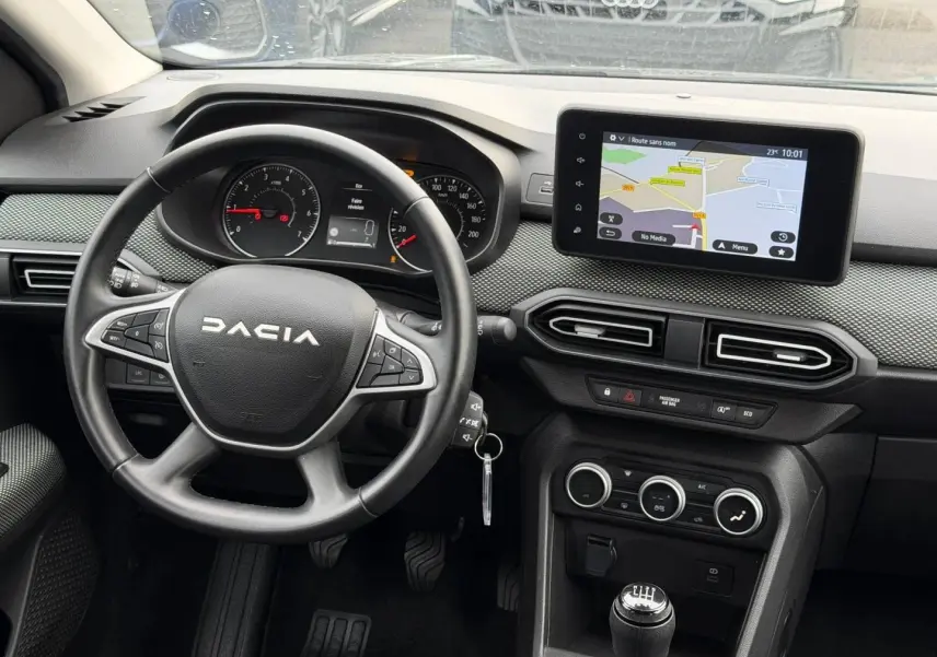 Vue intérieure du tableau de bord et volant noir du Dacia Jogger 2025 avec écran tactile et commande manuelle.