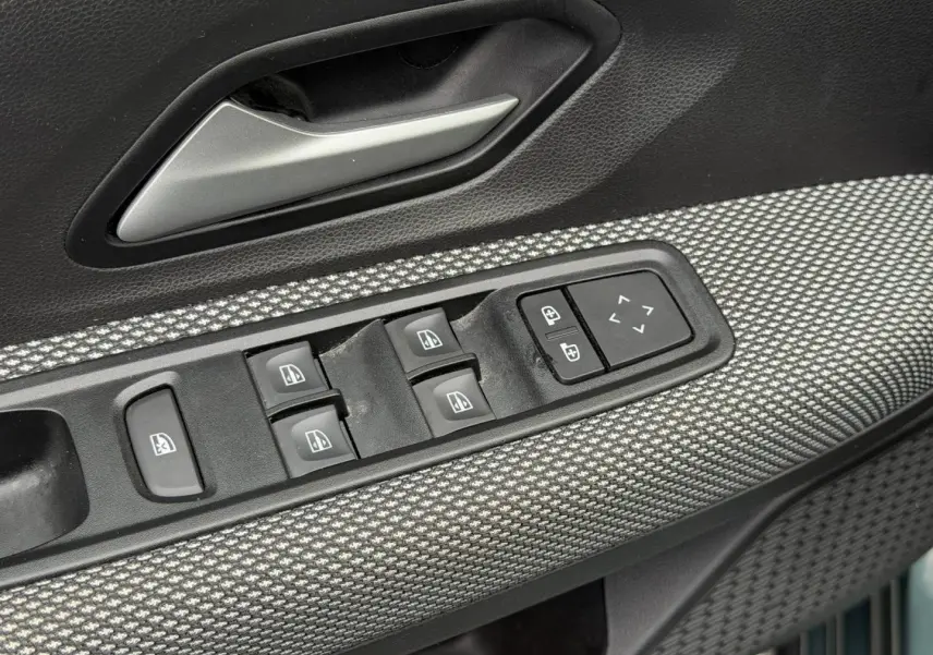 Gros plan sur la commande des vitres électriques et rétroviseurs sur la porte avant gauche du Dacia Jogger 2025.
