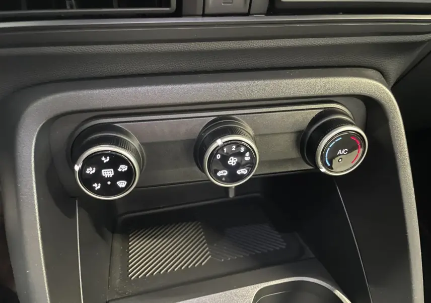 Vue rapprochée des commandes manuelles de climatisation noire dans l’habitacle de la Citroën C3 blanche 2025.