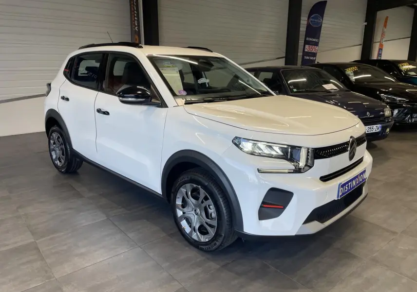 Citroën C3 blanc vue 3/4 avant droit en intérieur avec barres de toit noir brillant et jantes AZURITE.