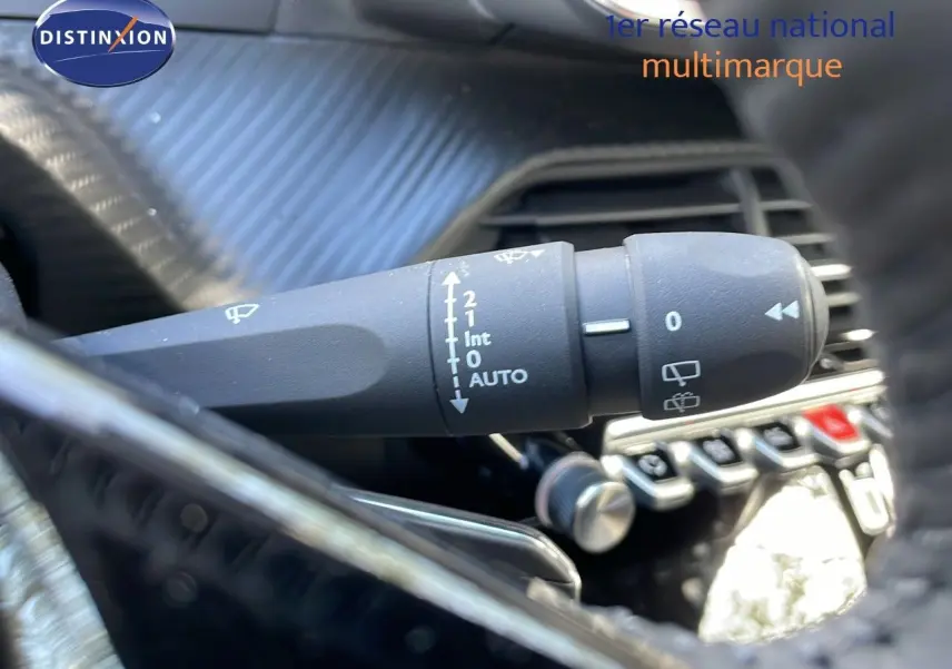 Gros plan sur la commande d'essuie-glace du Peugeot 2008 2025, avec tableau de bord noir texturé en arrière-plan.