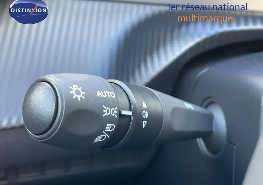 Gros plan sur la commande des phares du Peugeot 2008 gris Artense, montrant les réglages automatiques et feux antibrouillard.