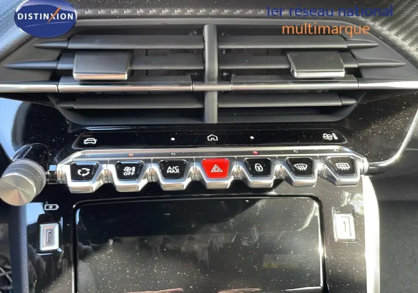 Gros plan sur la console centrale du Peugeot 2008 2025, boutons de commande et aérateurs noirs brillants.