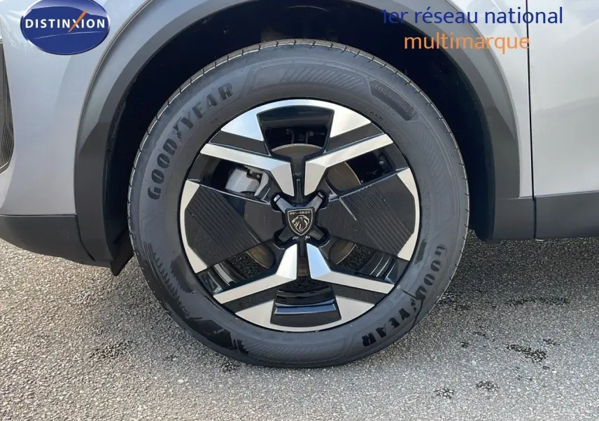 Gros plan sur la roue avant gauche du Peugeot 2008 gris Artense métal avec jante alliage bicolore moderne.