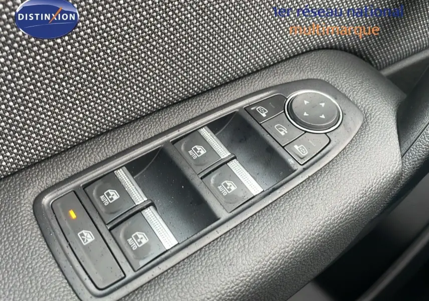 Gros plan sur les commandes des vitres électriques côté conducteur du Renault Captur noir étoile métal avec toit beige.