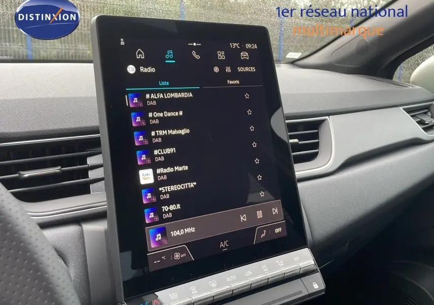 Vue intérieure du tableau de bord du Renault Captur E-Tech Hybrid 2025, avec écran tactile central affichant la radio numérique.