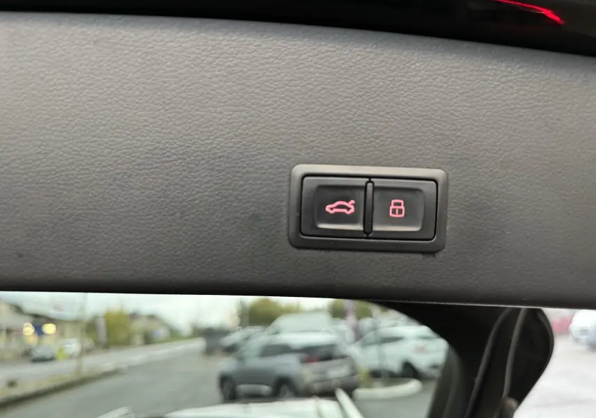 Gros plan sur les boutons d'ouverture et de verrouillage du coffre, intérieur noir de l'Audi A6 Avant Allroad 2016.