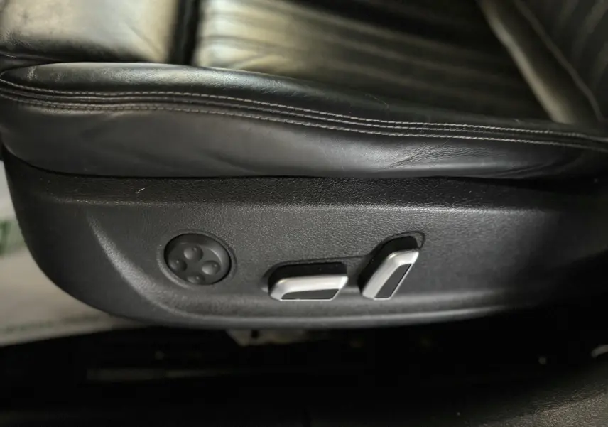 Gros plan sur les commandes de réglage électrique du siège en cuir noir de l'Audi A6 Avant Allroad 2016.