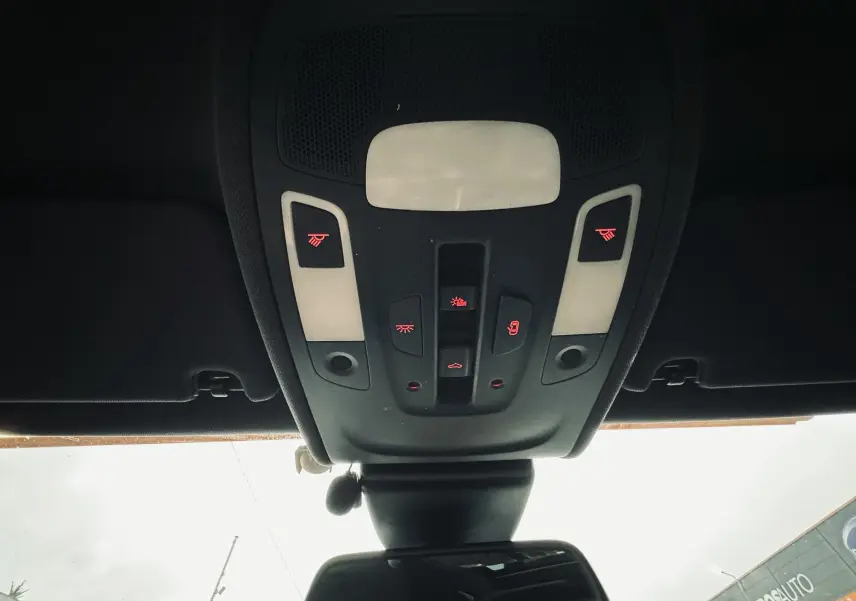Vue en contre-plongée du plafonnier noir avec commandes lumineuses rouges dans l’habitacle d’une Audi A6 Avant Allroad noire.