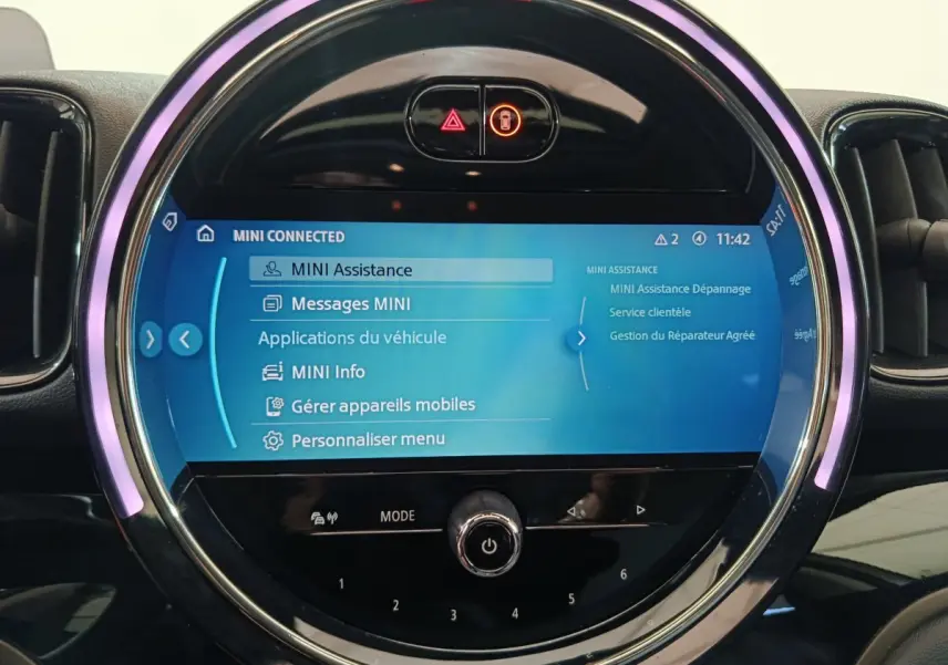 Écran tactile central rond allumé du MINI Countryman blanc, affichant le menu MINI Connected en intérieur.