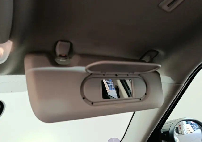 Miroir de courtoisie ouvert côté droit dans l'habitacle d'un MINI Countryman blanc, vue rapprochée intérieure.