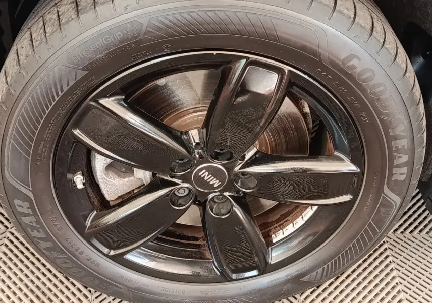 Gros plan sur la jante noire brillante et le pneu Goodyear d'une MINI Countryman blanche hybride rechargeable.