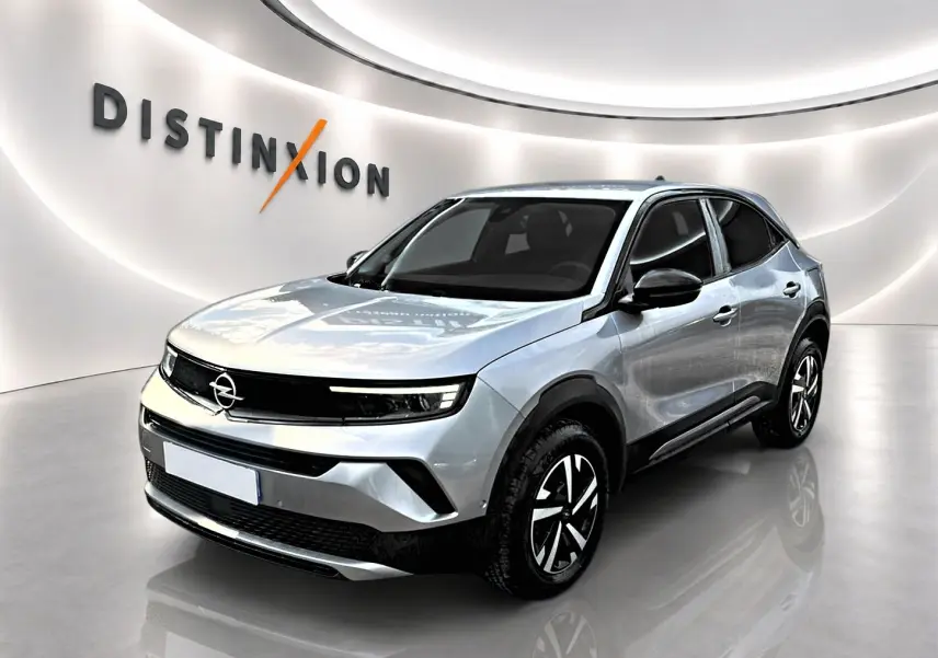Opel Mokka gris en 3/4 avant droit, avec jantes noires et détails noirs contrastants sur carrosserie.