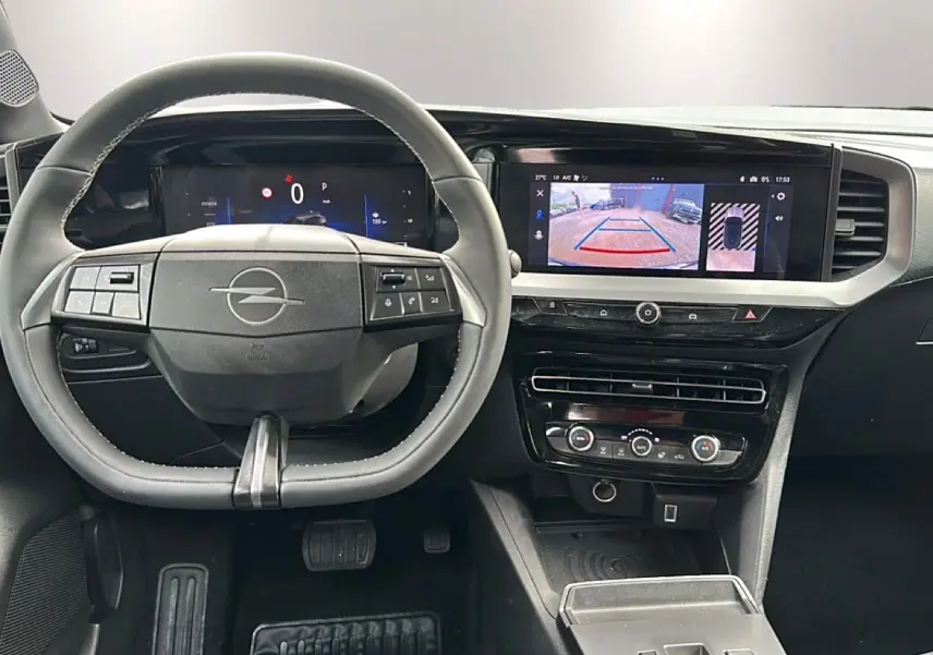 Vue intérieure frontale du tableau de bord gris de l'Opel Mokka 2025 avec écran tactile et volant multifonction.